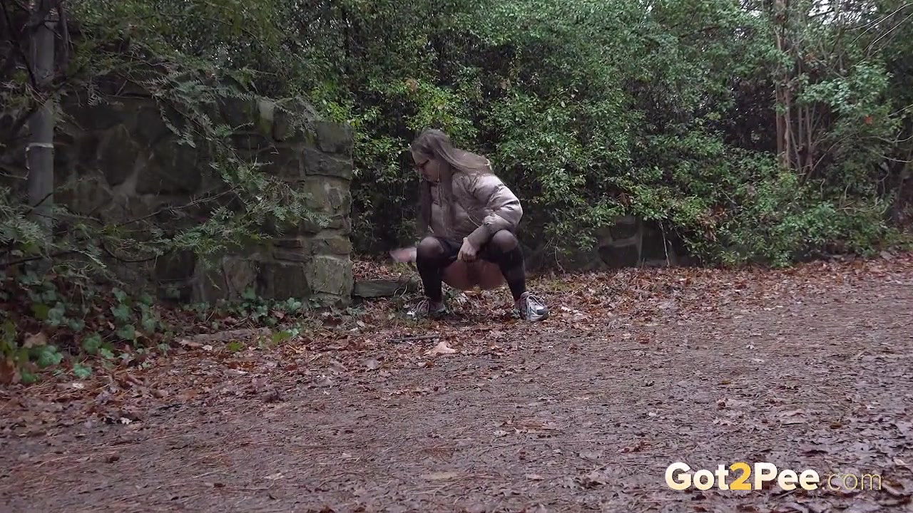 Barbe squats and pees on the ground in the rain