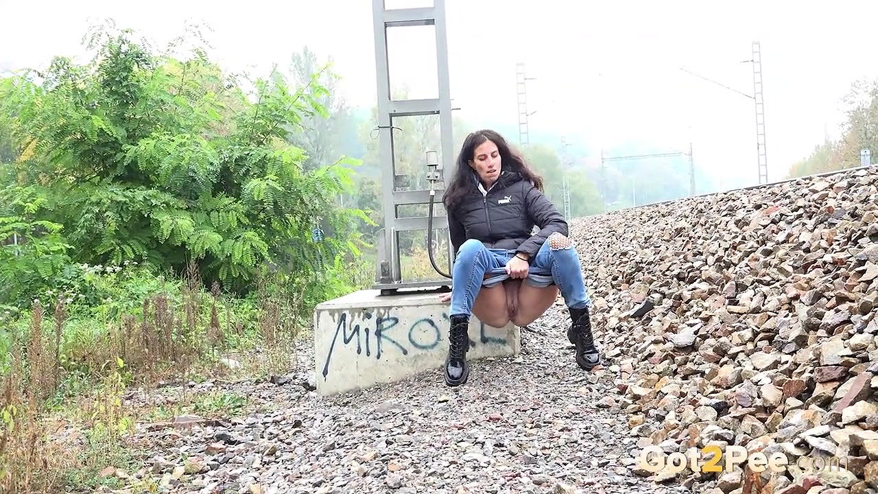 Ali B squats and pees near the train tracks