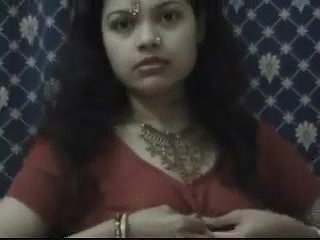 Young brunette in indian national dress strips for the camera