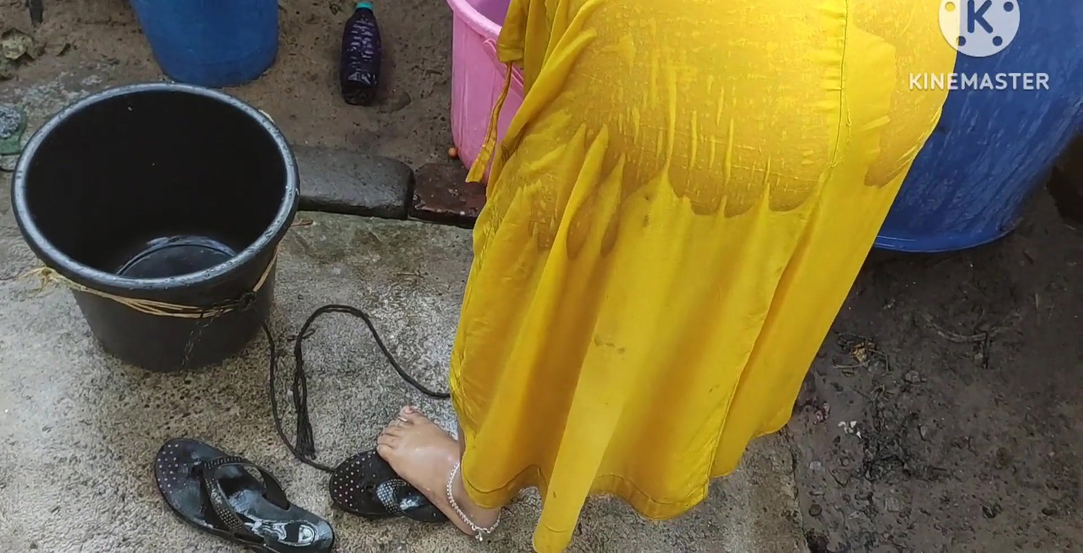 Indian house wife bathing outside