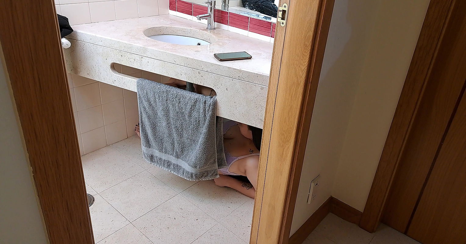 Stepsister receives facial cumshot through a hole in the sink