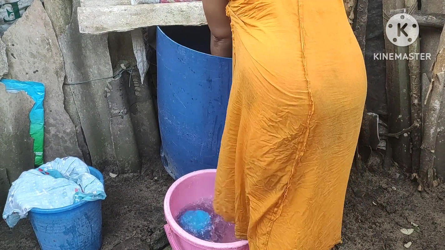 Indian house wife bathing outside with