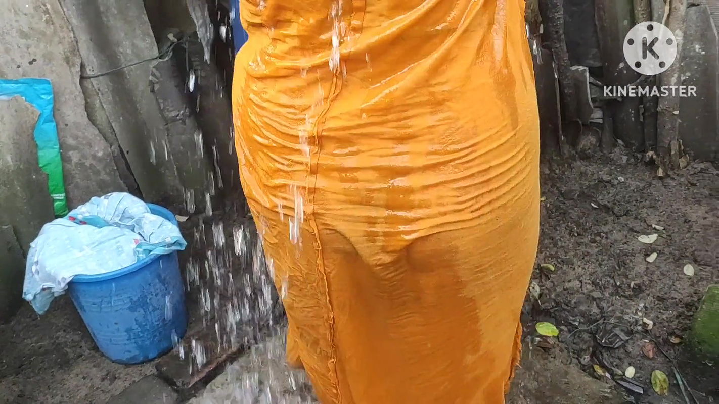 Indian house wife bathing outside with