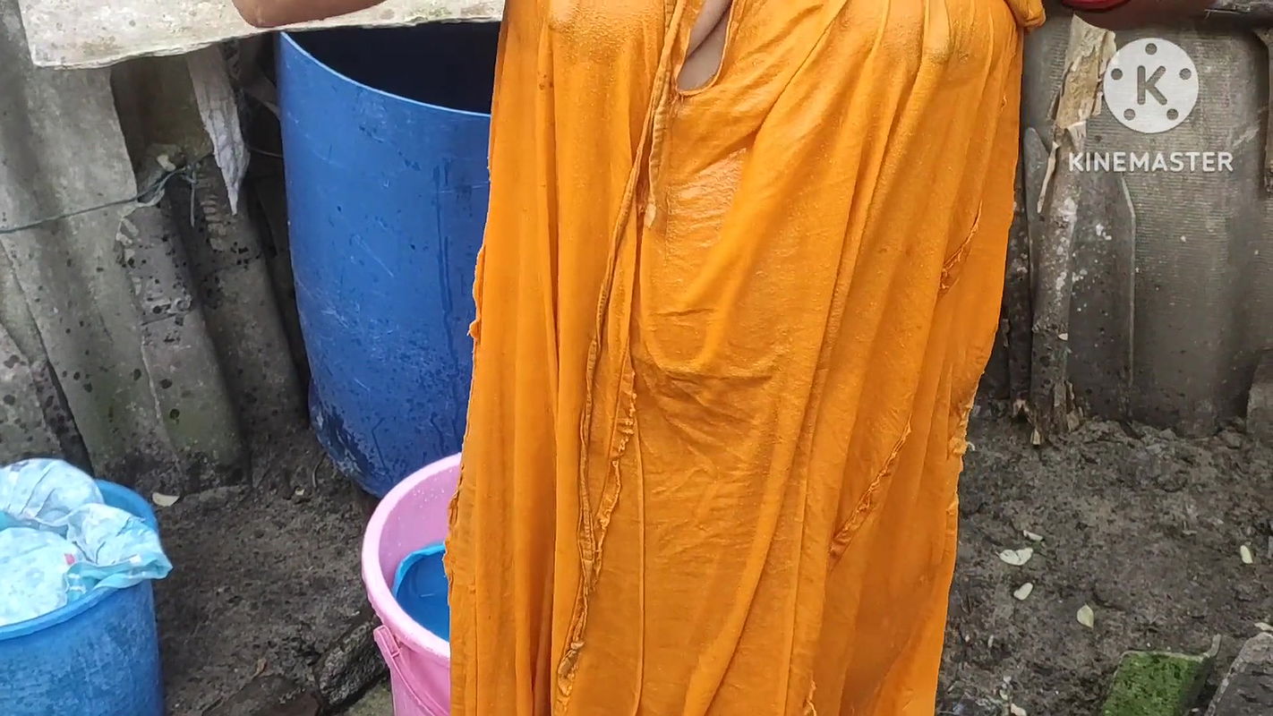 Indian house wife bathing outside with
