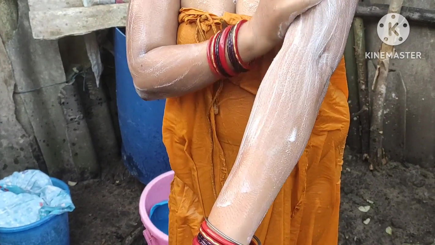 Indian house wife bathing outside with