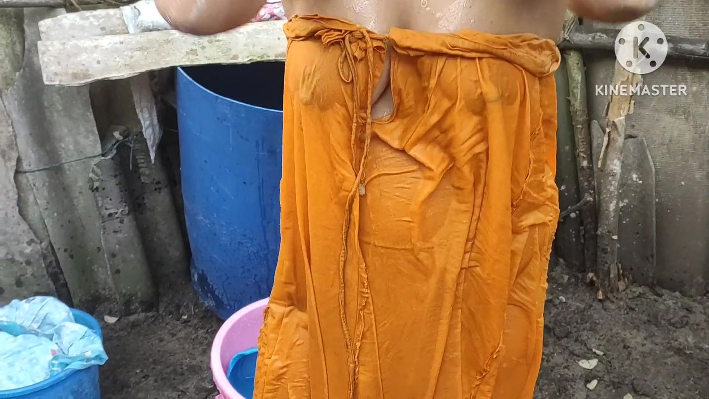 Indian house wife bathing outside with