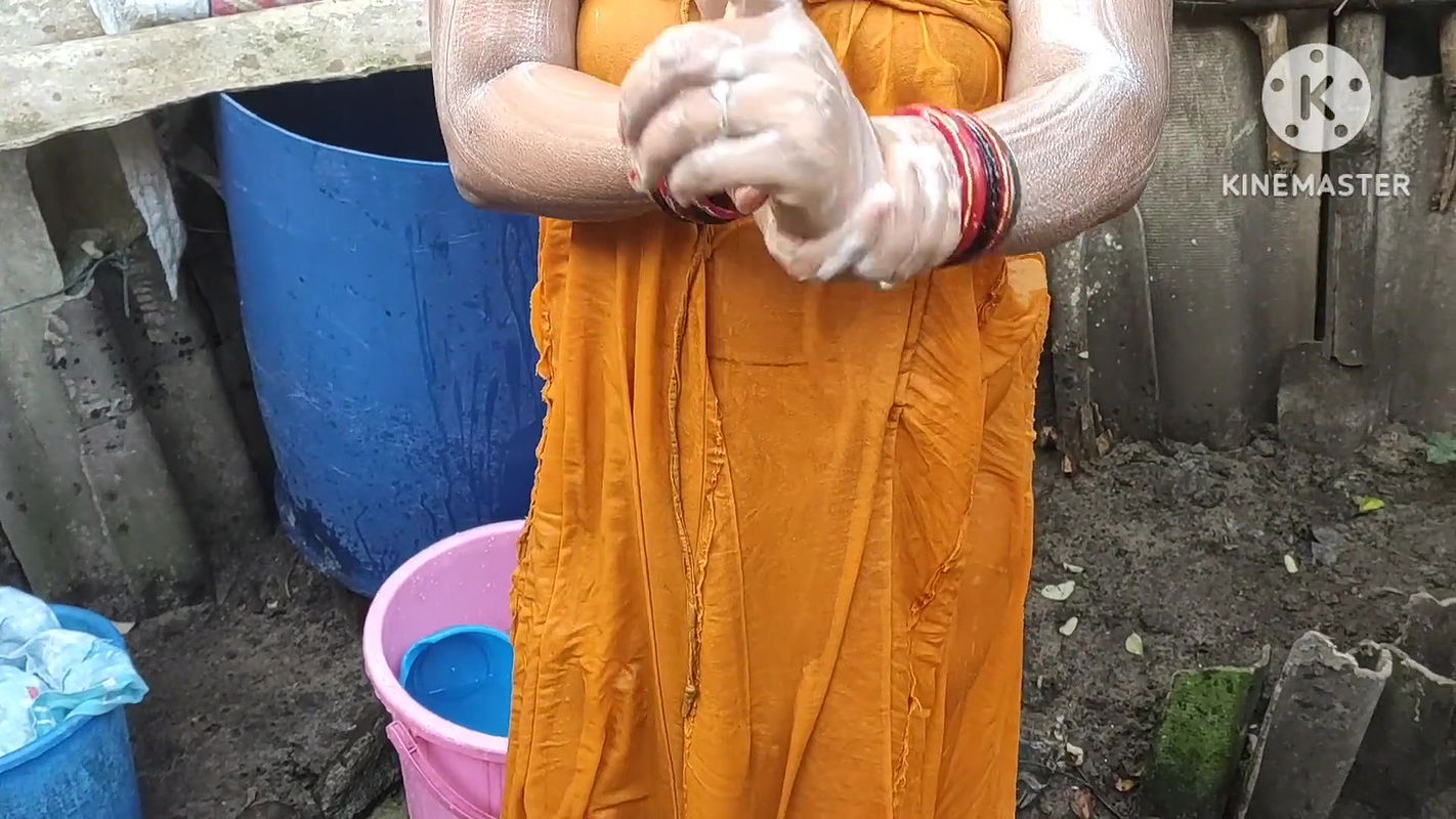 Indian house wife bathing outside with