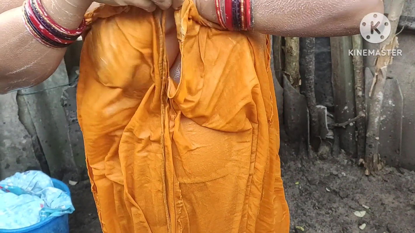 Indian house wife bathing outside with