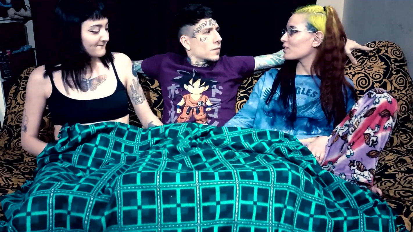 Punk dude with lots of tattoos is having a threesome with two skinny teens