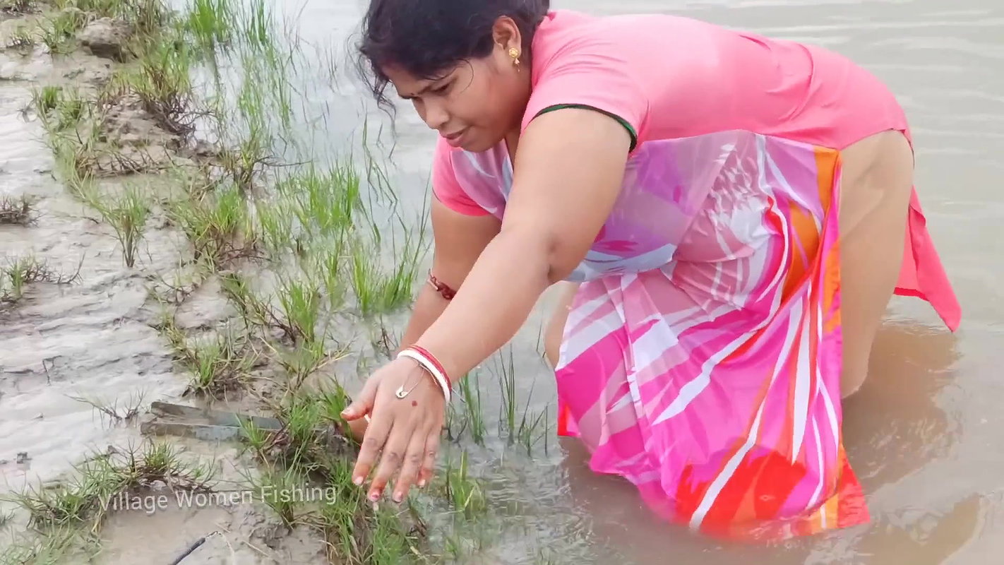 x Village women mud crab catching in the shore of Ba