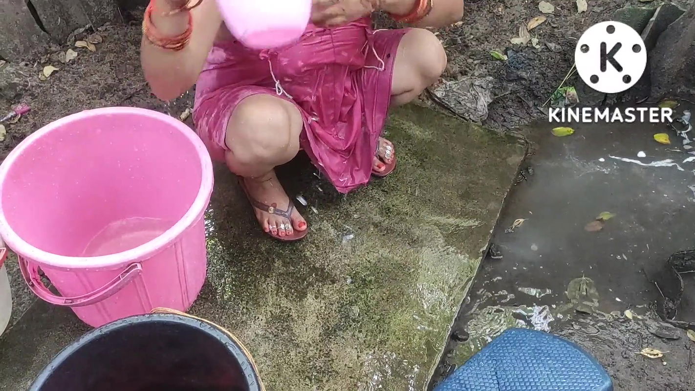 Indian house wife bathing outside