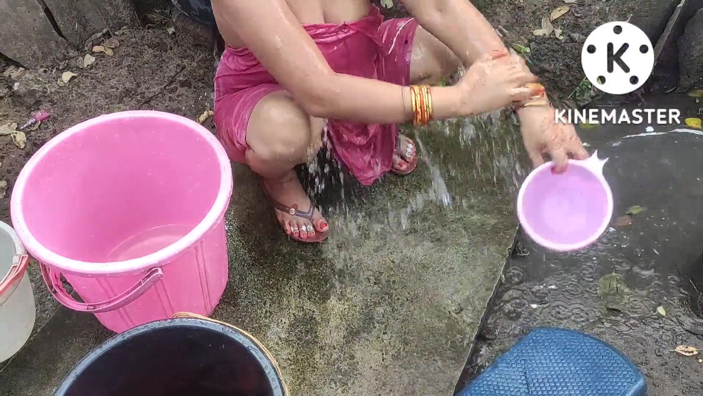 Indian house wife bathing outside