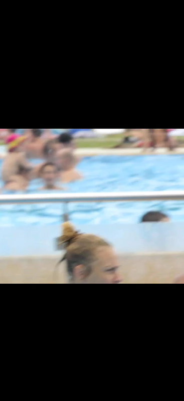 Slim young babe with massive boobs captured in pool