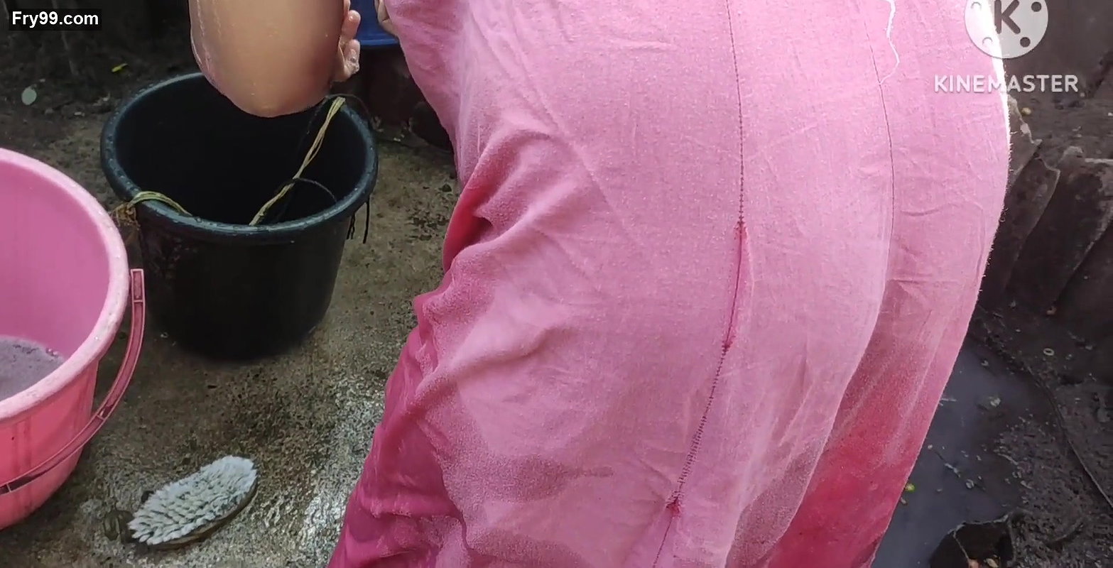 Indian house wife bathing outside with.