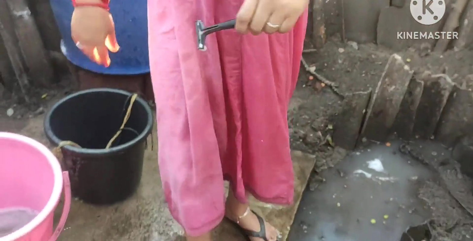 Indian house wife bathing outside with.